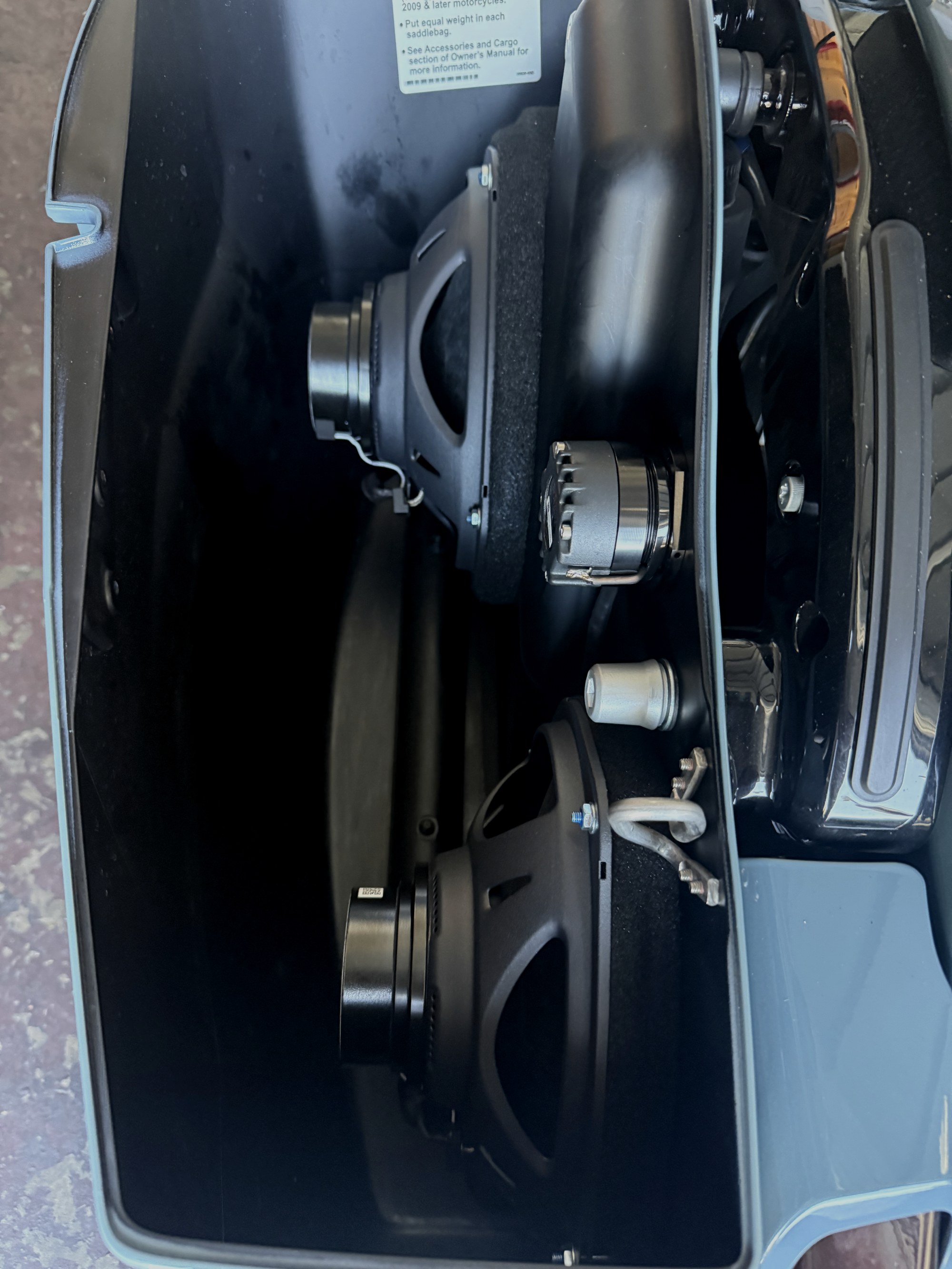 Two woofers and a small driver mounted inside a Harley-Davidson saddlebag